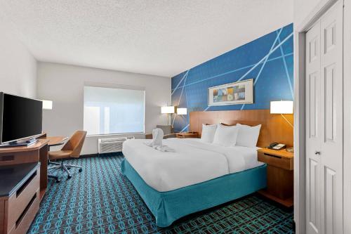 a hotel room with a large bed and a desk at Comfort Inn & Suites Berea in Berea