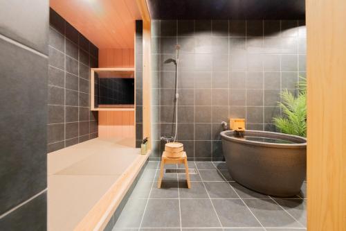 a bathroom with a large tub and a shower at 栞 畳で整う貸切サウナ付きの一軒家 usjまで約10分 寝室6部屋 バスルーム3台 in Osaka