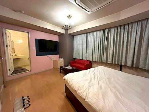 a bedroom with a bed and a flat screen tv at ホテルクレアトゥール安城 in Wada