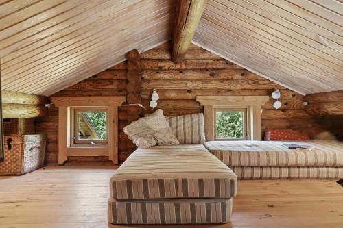 a bedroom in a log cabin with a bed and windows at Nordic Log Cabin With Views Over The Fields in Hals