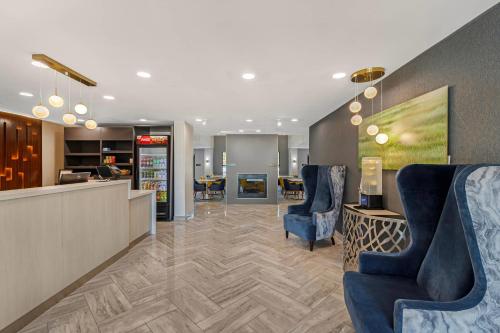 a lobby with two blue chairs and a counter at Comfort Inn & Suites Savannah Airport in Savannah