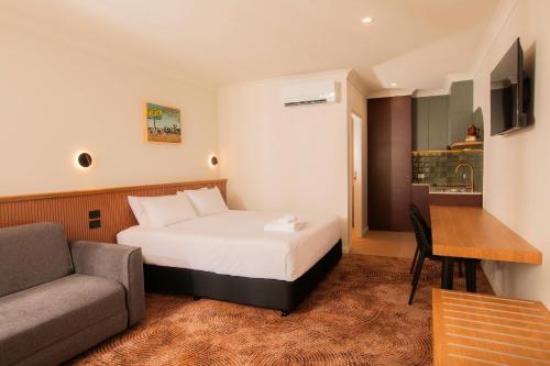 a hotel room with a bed and a couch at The Alluna Motel, an Ascend Collection Hotel in Armidale