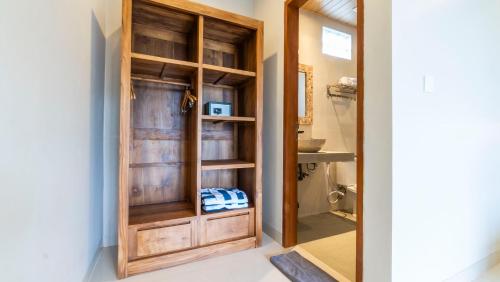 a bathroom with a wooden closet with a glass door at Lavana Ubud in Ubud