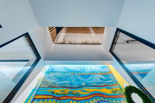 Cette chambre dispose d'un sol en verre et d'une peinture murale. dans l'établissement Artrock Experience Loft Gallery, à Ermoúpoli