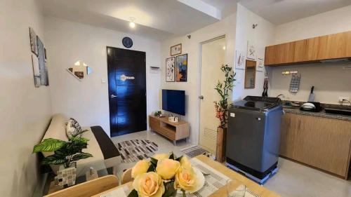 a living room with a table and a kitchen at Ann Cozy Living in Cebu City