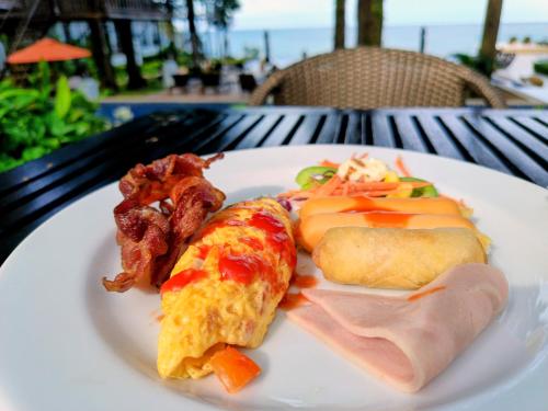a plate of food with eggs ham and bacon at Chang Buri Resort & Koh Chang Hillside in Ko Chang