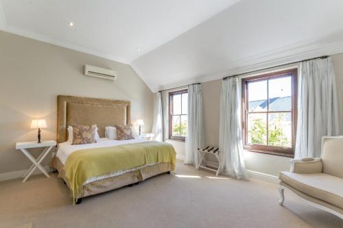 ステレンボッシュにあるWinelands Golf Lodges 15のベッドルーム1室(ベッド1台、椅子、窓付)