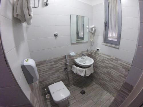 a small bathroom with a sink and a toilet at Hotel Runa in Mugnano di Napoli