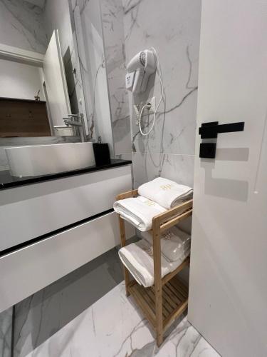 a bathroom with a sink and a shelf with towels at Brianza Home in Giussano