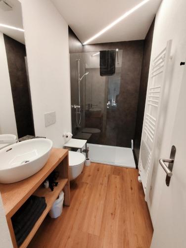 a bathroom with a white sink and a shower at B&B Berninapass Poschiavo Panorama in Poschiavo