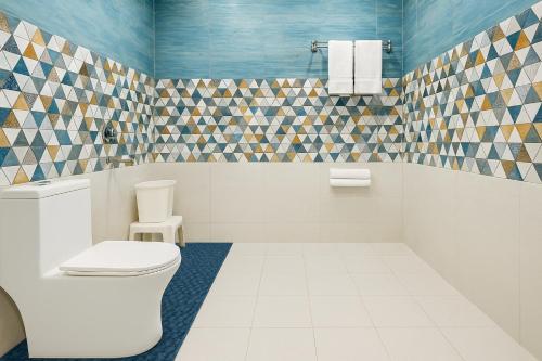 uma casa de banho com WC e azulejos azuis e brancos em Hotel The SSB - ! luxury balcony rooms ! mountain view ! rooftop cafe ! big parking ! property of the year ! em Mussoorie