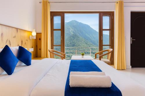 um quarto com uma cama grande com vista para uma montanha em Hotel The SSB - ! luxury balcony rooms ! mountain view ! rooftop cafe ! big parking ! property of the year ! em Mussoorie