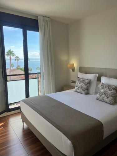 a bedroom with a bed with a view of the ocean at Apartahotel Punta Calera in Los Alcázares