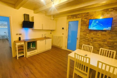 a kitchen with a table and a tv on a brick wall at QUEEN HOME Emanuelle in Venice