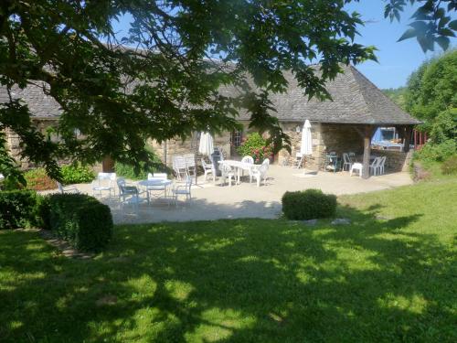een huis met stoelen en een tafel in een tuin bij La Maison de Vigneron in Saint-Côme-dʼOlt