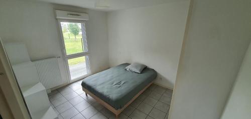 a small bed in a room with a window at Cosy Appartement proche Bordeaux Proche centre ville in Villenave-dʼOrnon