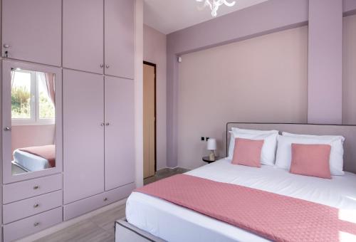 a bedroom with a large bed with a pink blanket at Green Hill Villa in Daratso