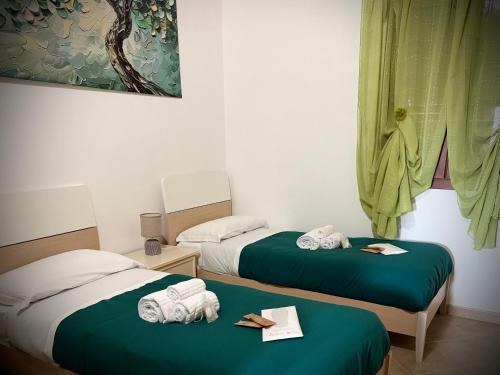 two beds in a room with towels on them at Villa Sofia Casa Vacanze in Marconia