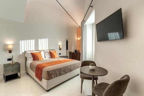 a bedroom with a bed and a tv on a wall at Residenze Piazza Dante in Naples