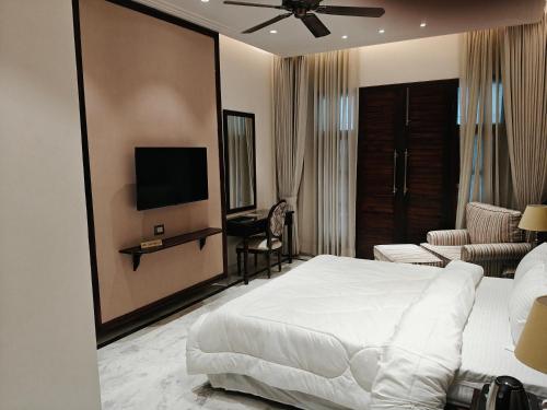 um quarto de hotel com uma cama e uma televisão em The Himalayan Residency em Duttnager