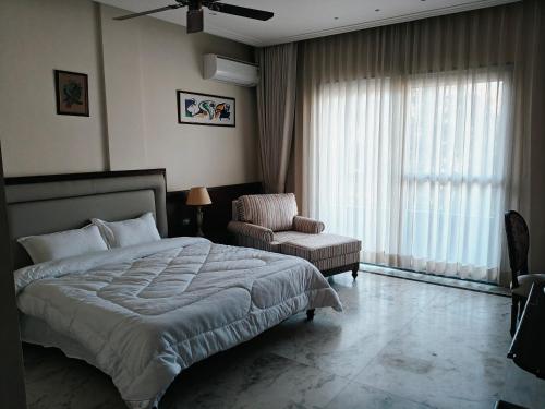 um quarto com uma cama, uma cadeira e uma janela em The Himalayan Residency em Duttnager