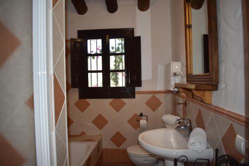a bathroom with a sink and a toilet and a window at Finca Lagarillo with private Pool in Cómpeta