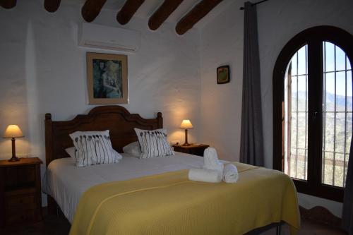 a bedroom with a bed with towels on it at Finca Lagarillo with private Pool in Cómpeta