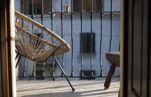 einen Stuhl auf einer Veranda mit einem Zaun in der Unterkunft Loft 1855 'centro cittá' in Domodossola