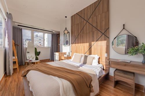 a bedroom with a large bed and a desk at The Morris Central Hotel - O'TEL in Da Lat