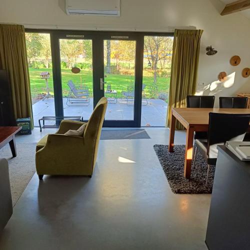 a living room with a table and chairs and a dining room at Natuurlijk leuk in Sterksel
