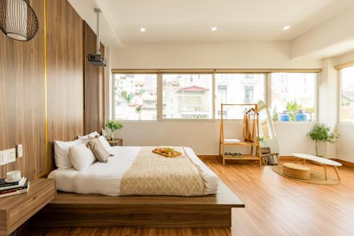 a bedroom with a bed and a large window at The Morris Central Hotel - O'TEL in Da Lat