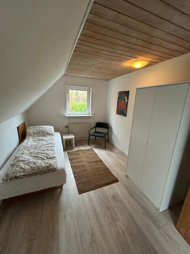 an attic bedroom with a bed and a window at Hyggelig 2 plans villa i Hørning in Hørning