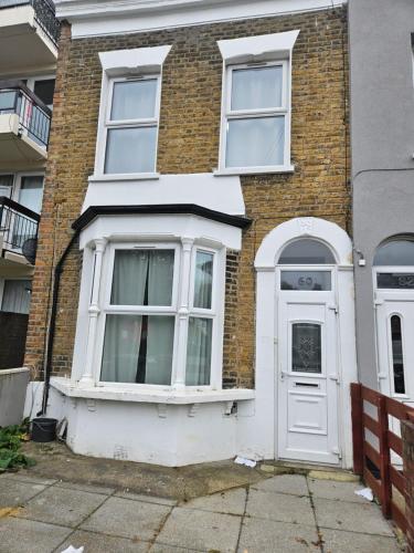 ロンドンにあるSky homesの白いドアと窓のあるレンガ造りの家