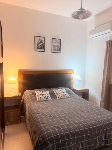 ein Schlafzimmer mit einem Bett und zwei Nachttischen mit Lampen in der Unterkunft Loano III - Confort Moderno en PB! in Belén de Escobar