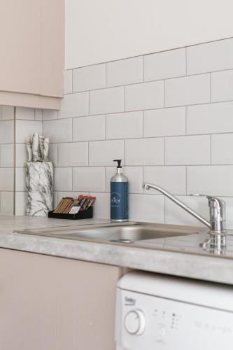 a kitchen counter with a sink and a bottle of soap at Luxurious 2 Bedroom City Centre Apartment Walking Distance to Everything Sleeps 6 in Belfast