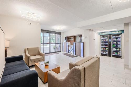 a living room with a couch and chairs and a table at Clarion Pointe Winston - Salem Downtown in Winston-Salem