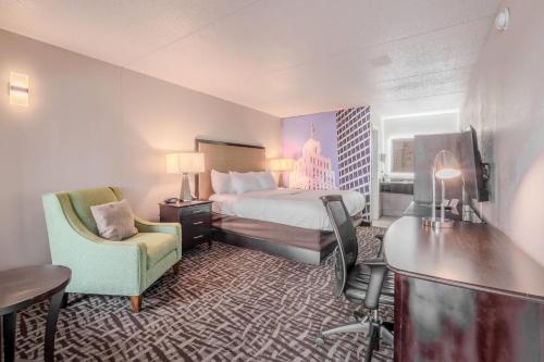 een hotelkamer met een bed, een bureau en een stoel bij Clarion Pointe Winston - Salem Downtown in Winston-Salem