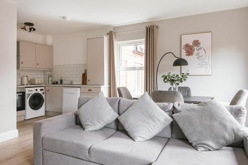 a living room with a couch and a kitchen at Luxurious 2 Bedroom City Centre Apartment Walking Distance to Everything Sleeps 6 in Belfast