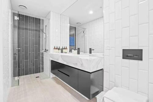 une salle de bain blanche avec lavabo et douche dans l'établissement Decent views 3BR in Doncaster Central, à Doncaster