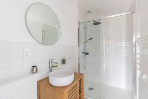 a white bathroom with a sink and a mirror at maison Amboise in Limeray