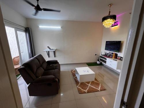 バンガロールにある1 BHK Flat with good amenities in Mysore Roadのソファとテレビのあるリビングルーム