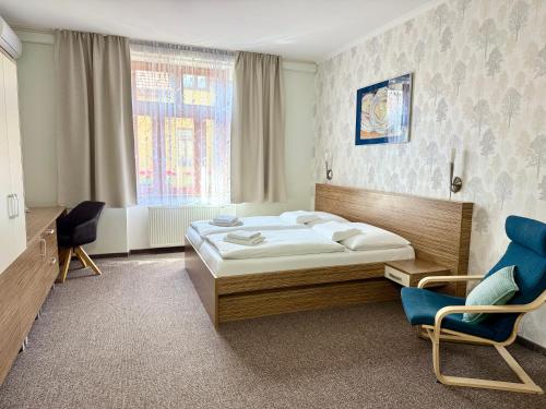 een slaapkamer met een bed en 2 stoelen. bij Penzión Hradbová Old Town Residence & SPA in Košice