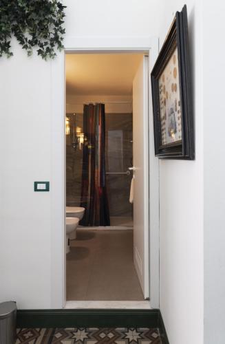 a bathroom with a door open to a bathroom with a toilet at CASABONA1910 bed&breakfast in Vercelli