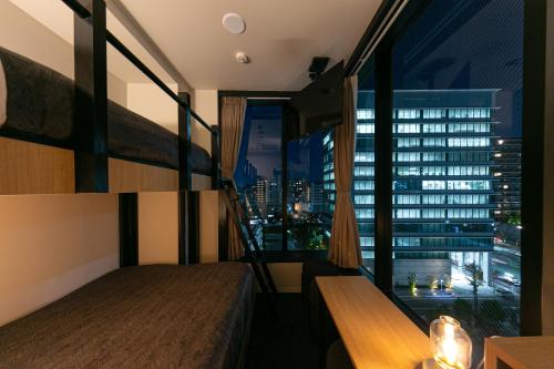 a hotel room with two beds and a large window at Hotel Edge Nakasu in Fukuoka