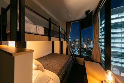 a room with two bunk beds and a window at Hotel Edge Nakasu in Fukuoka