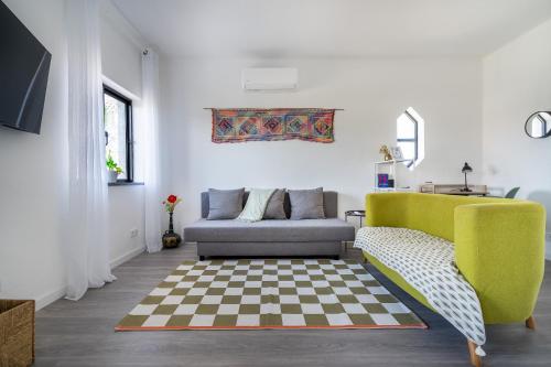 a living room with a couch and a checkered floor at Vivenda Aromas do Algarve in Monte Raposo