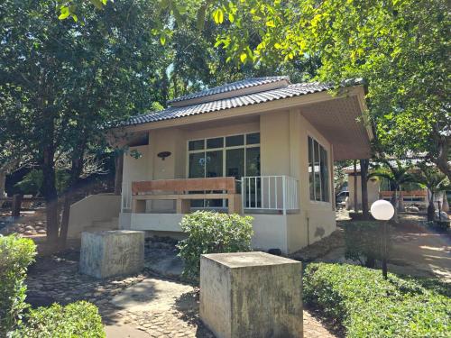 une petite maison avec un banc devant elle dans l'établissement ขวัญใจปราณ รีสอร์ท, à Ban Pak Nam Pran