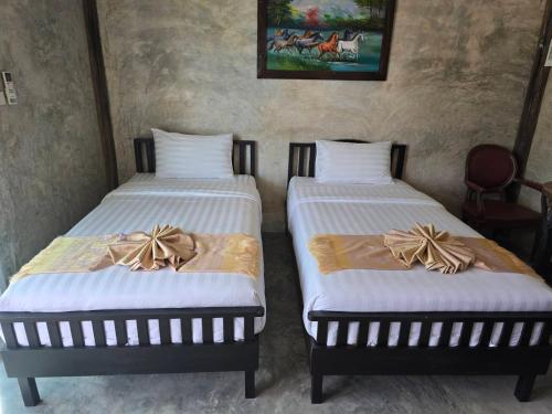deux lits côte à côte dans une pièce dans l'établissement ขวัญใจปราณ รีสอร์ท, à Ban Pak Nam Pran