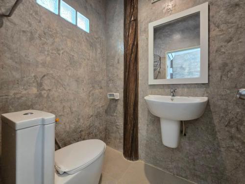 a bathroom with a white toilet and a sink at ขวัญใจปราณ รีสอร์ท in Ban Pak Nam Pran