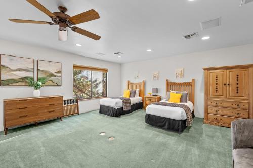 une chambre avec deux lits et un ventilateur de plafond dans l'établissement Rooftop Hot Tub Epic Red Rock Views, à Sedona